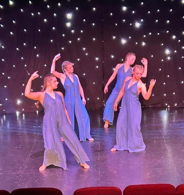 Tap dancers performing synchronised routine under blue lights